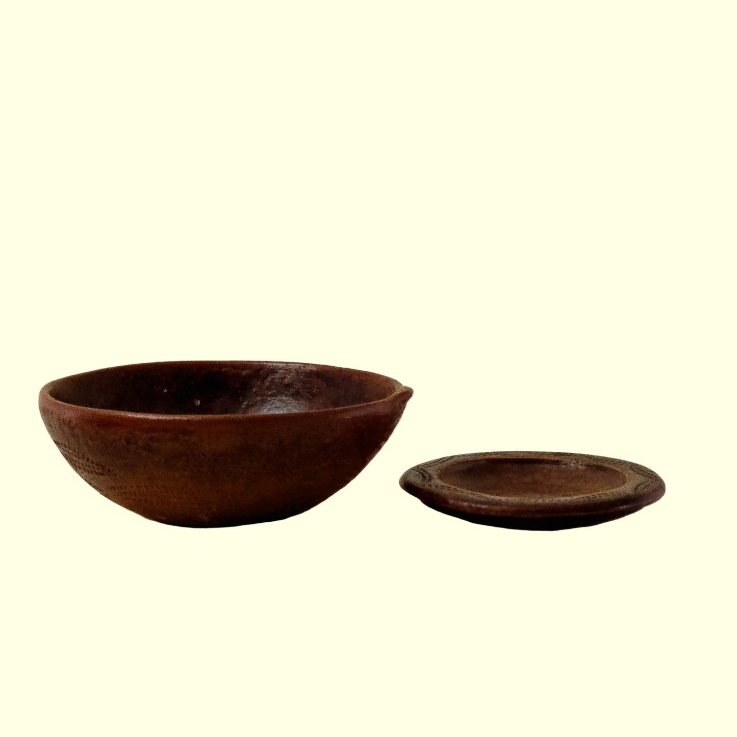 A 19c Columbian Redware bowl with a removable bottom plate, showcasing a rustic brown color and a smooth, rounded shape on a plain background.