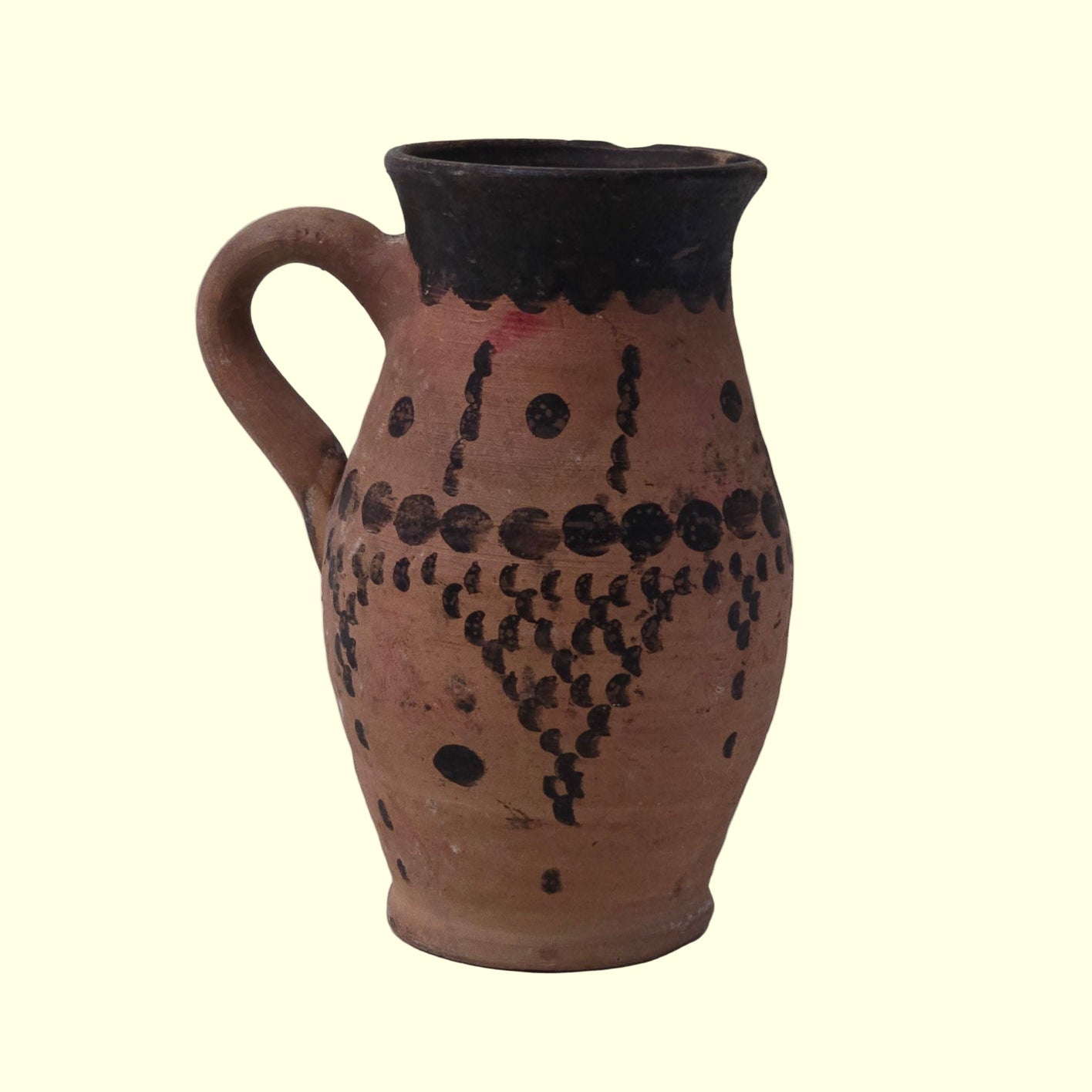 Ceramic pitcher with black patterns on a gray background