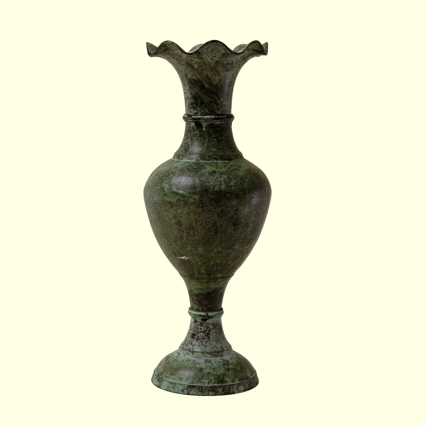 A fluted green vase with a textured surface, featuring vertical ridges and a flared top, set against a plain background.