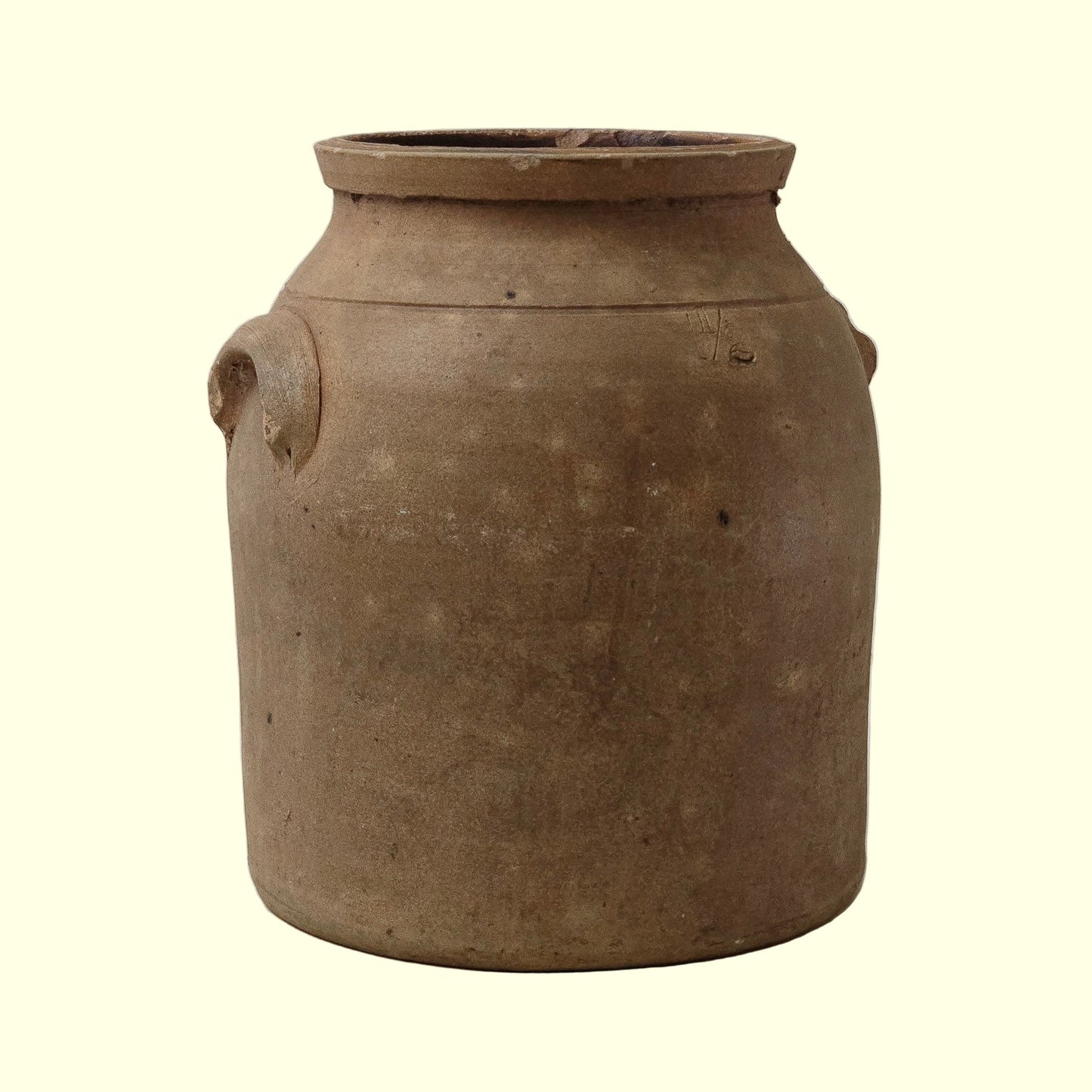 A terracotta crock with sturdy handles, featuring a warm, earthy hue and a timeworn patina.