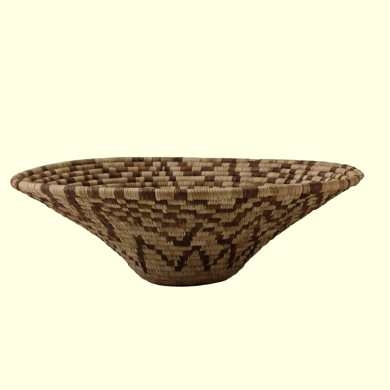 A handcrafted basket with geometric patterns and earthy tones, showcasing traditional weaving techniques.
