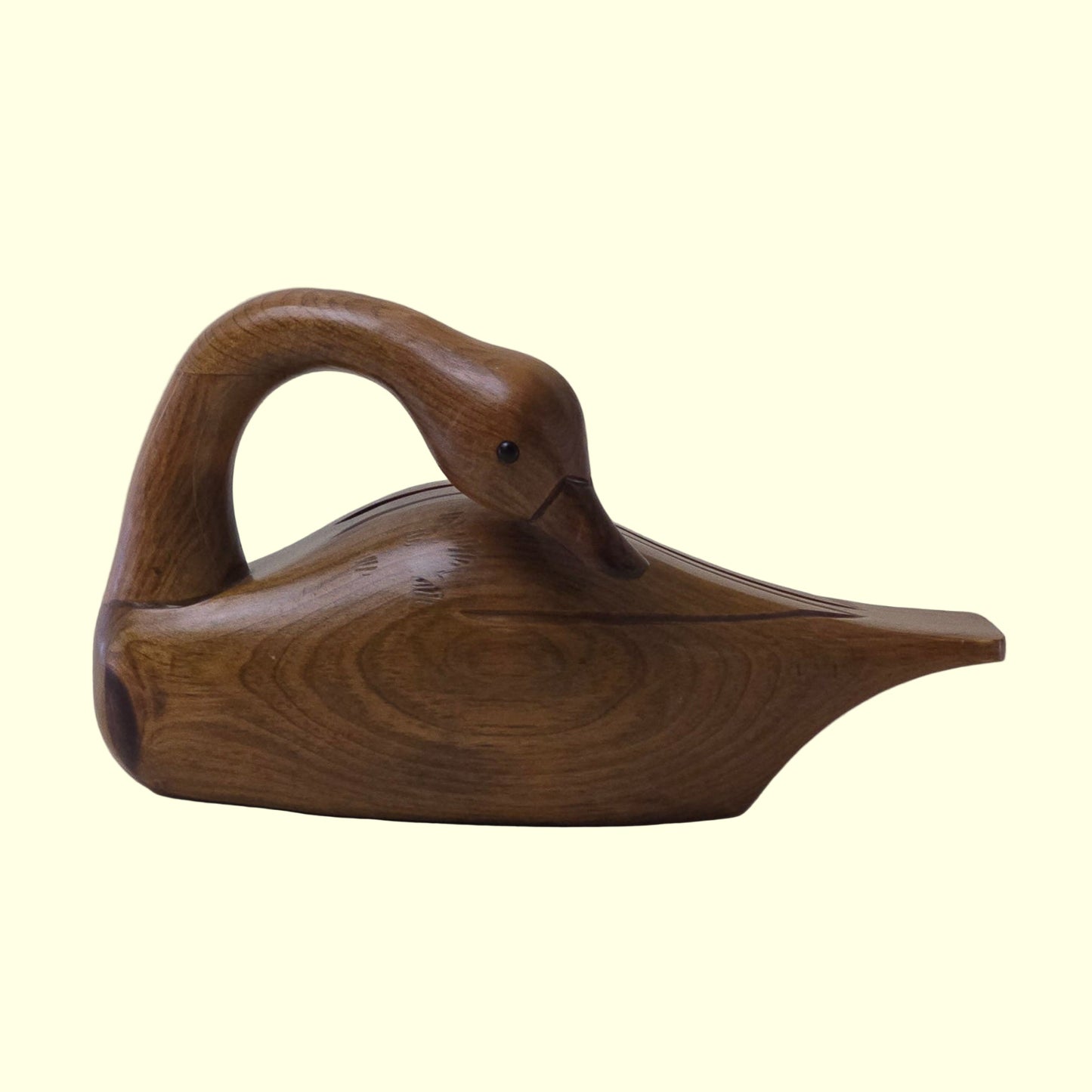 Wooden swan sculpture on a plain background