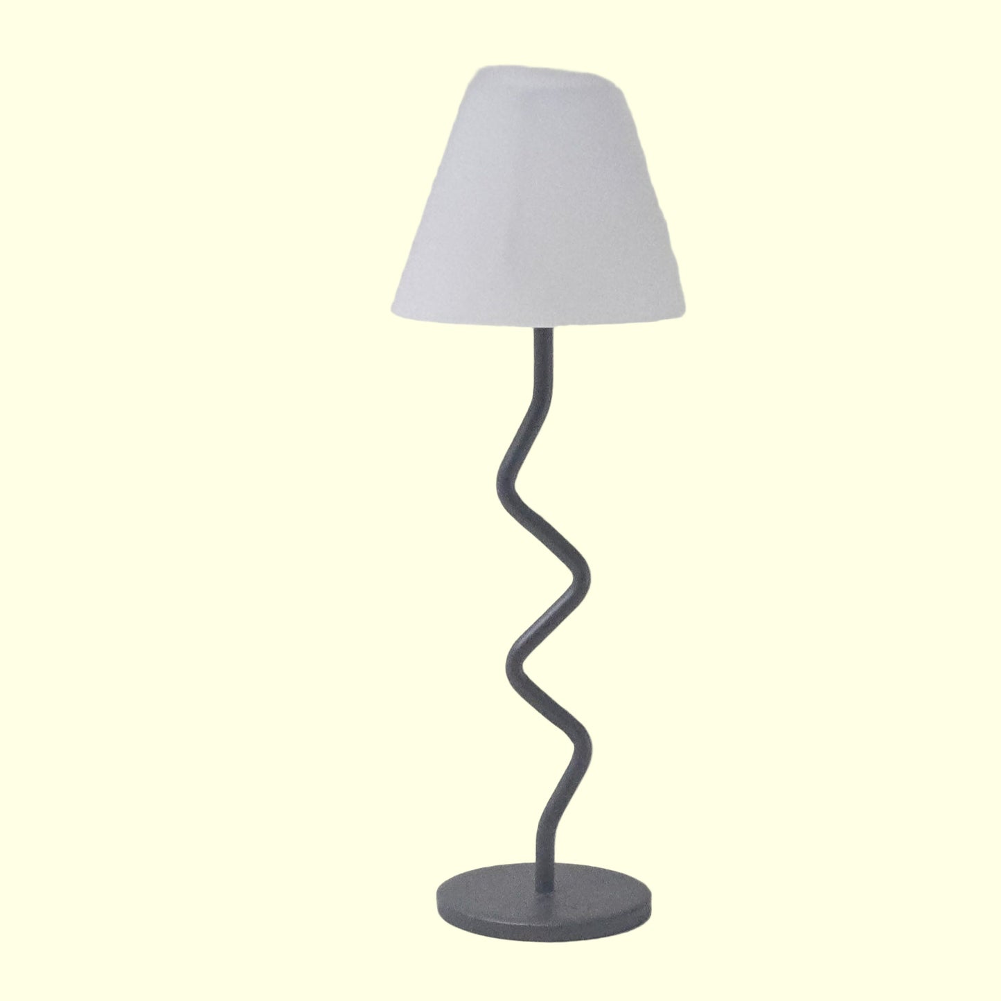 Floor lamp with a white shade and a black, wavy metal base on a light gray background