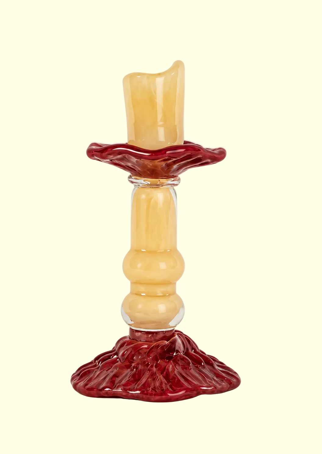 A vintage-style glass candlestick holder with a pale yellow ribbed stem and base accented by a deep red fluted rim and matching base, shown on a plain cream background.