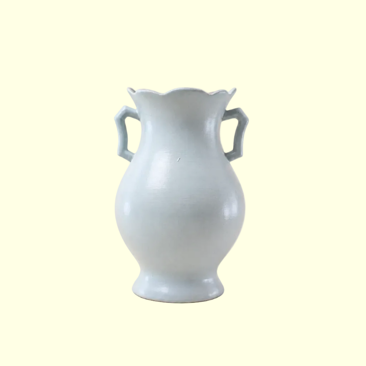 A light blue ceramic vase with a scalloped rim, a rounded body, and two loop handles, shown on a plain white background.