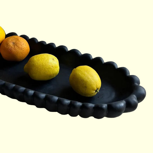 Black scallopped decorative tray with lemons and oranges 